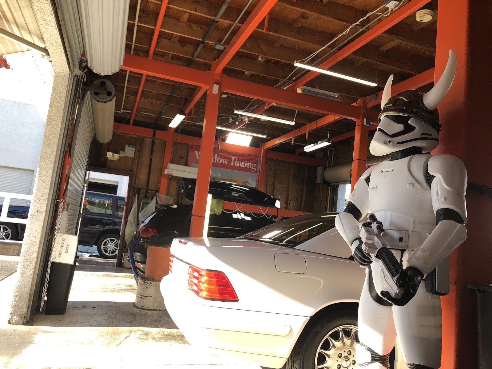 Detailing bay with window tinting banner and a Star Wars stormtrooper figure